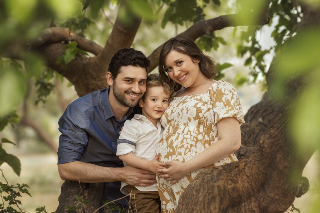 צילומי משפחה בטבע על רקע גזע עץ
