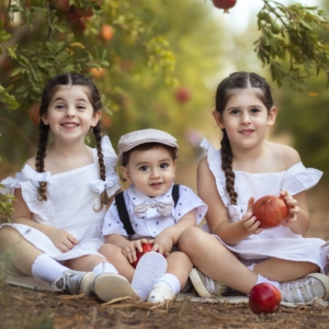 ילדים מצטלמים בפרדס עם רימונים ונהנים