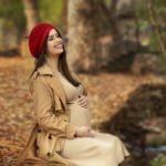 אישה צוחקת ומחזיקה בבטן הריונית